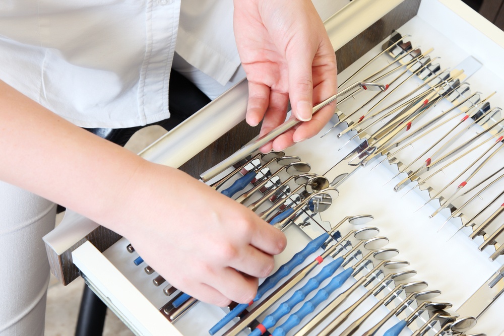 Dentist assistant organizes the dental tools drawer
